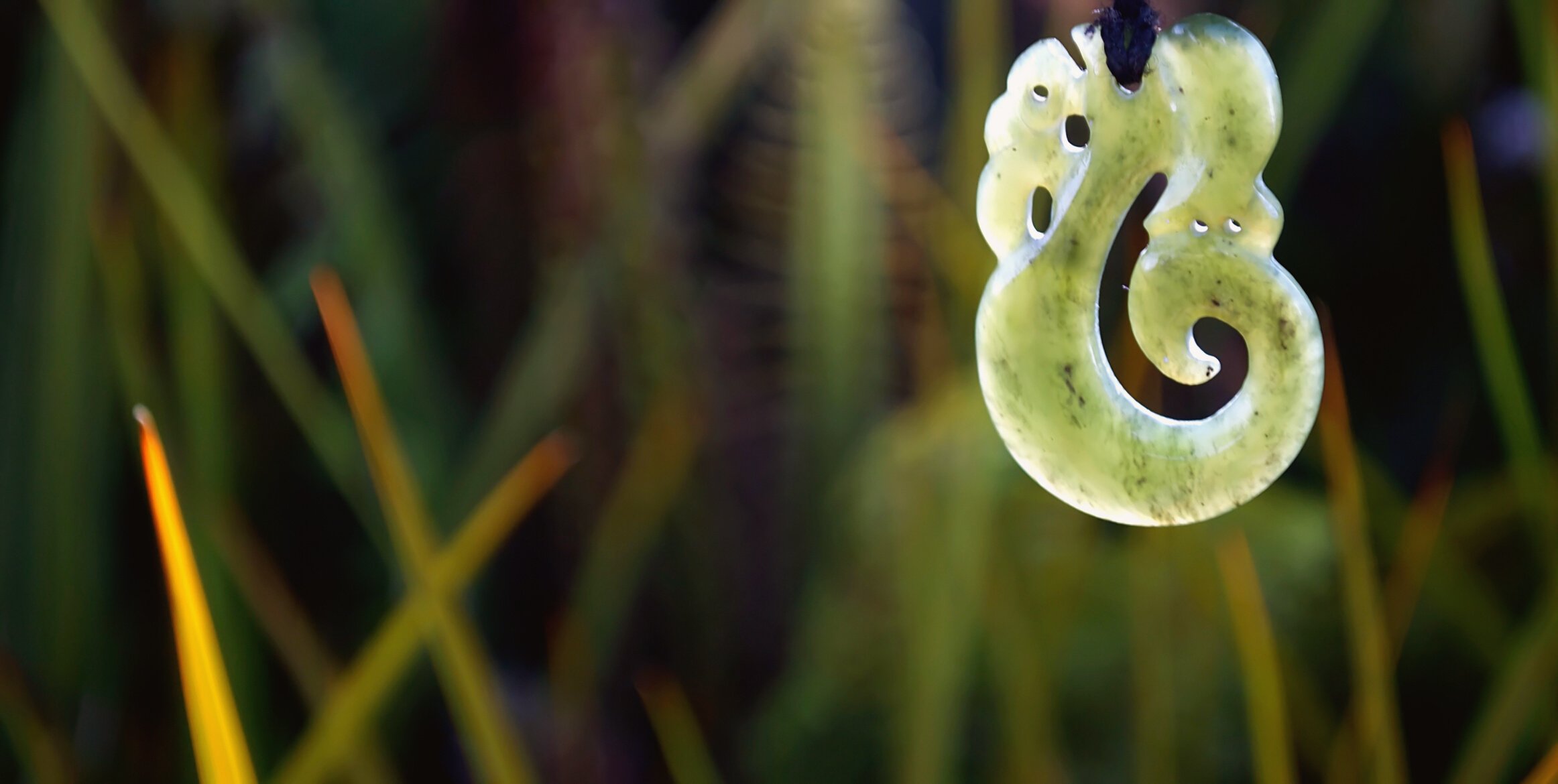 Typical Maori Pounamu with Native Flora Background